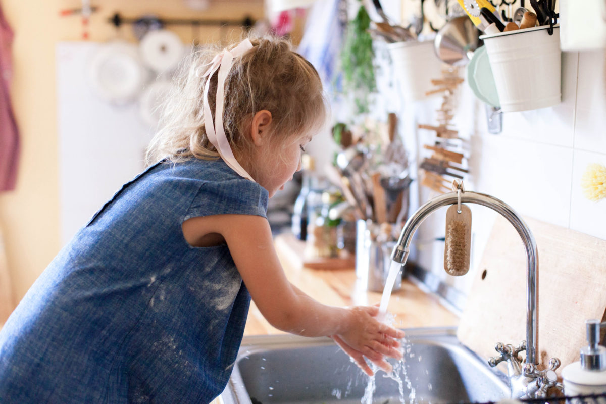 Kid Washing Hands At Home Under Water Tap. Child Girl In Flour After Cooking In Cozy Home Kitchen.